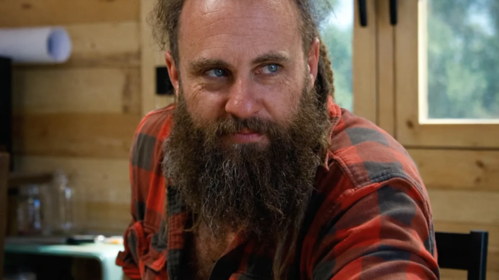 Chad Ollinger from Blind Frog Ranch shown in a high-quality close-up image inside a wooden cabin setting.